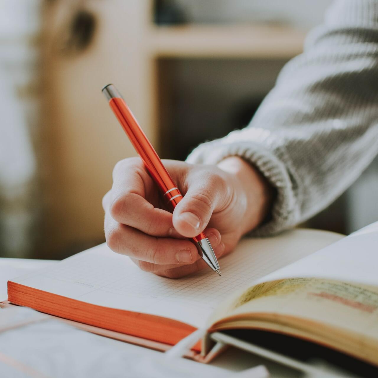 Person writing on a block with a ball pen